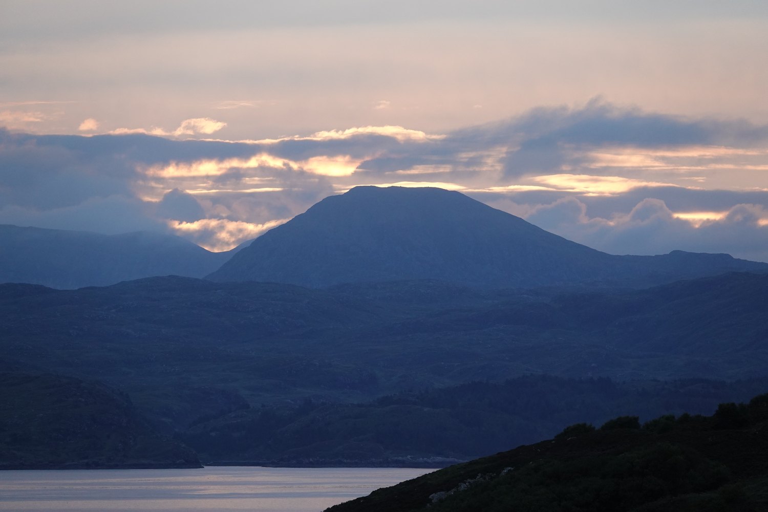 Sunset behind the Assynt mountains viewed from Drumbeg