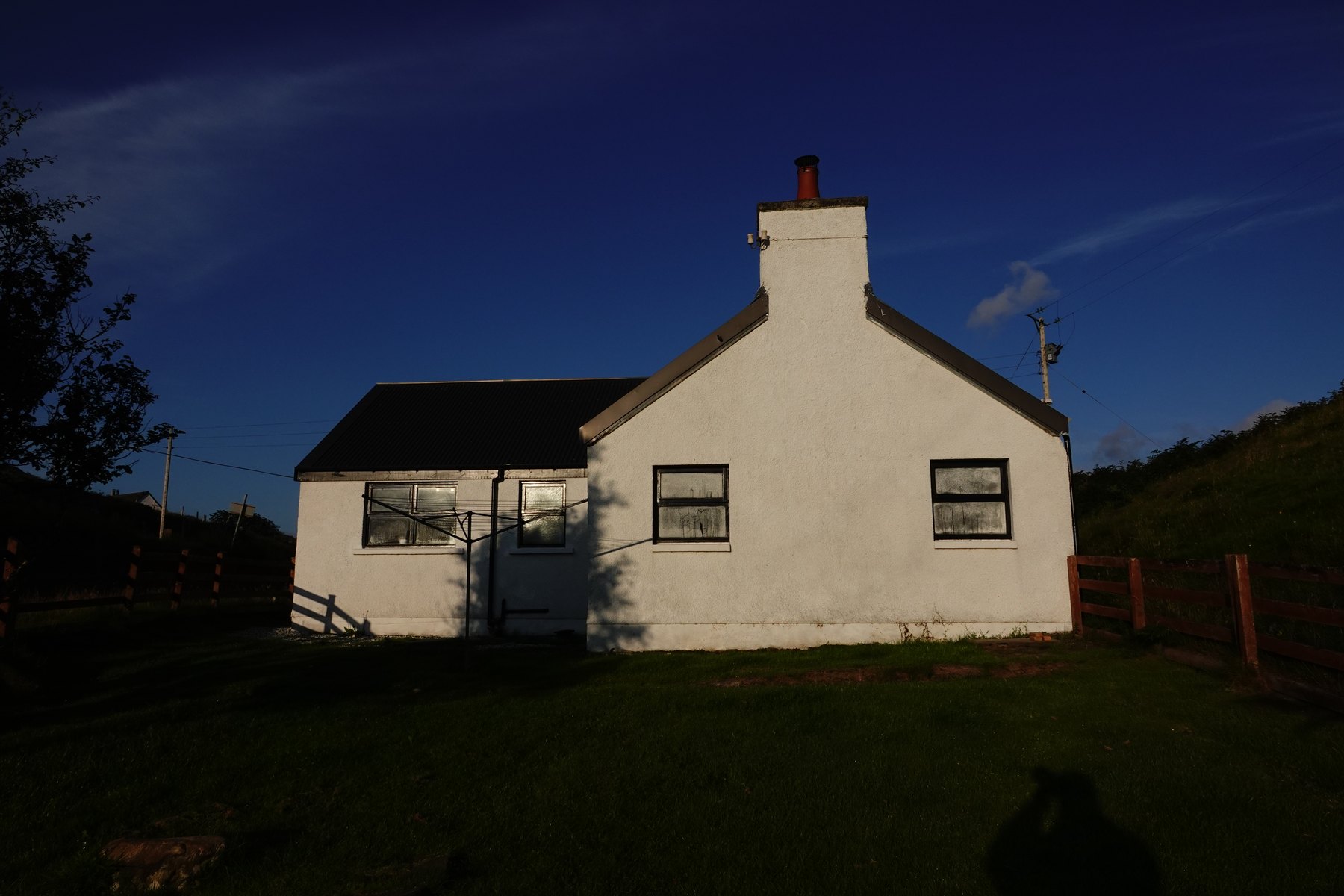The white exterior of Torbeg Cottage in evening light